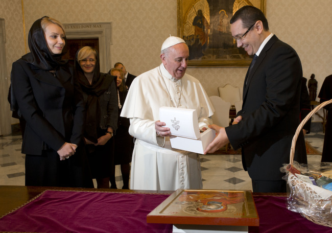 Pope Francis exchanges gifts with Romania’s Prime Minister Victor Ponta (right) and his wife Daciana Sarbu at the end of a private audience he held in his studio at the Vatican on Saturday.    AP-Yonhap
