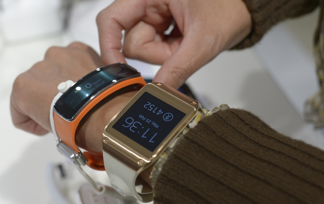 A woman wears the new Samsung Gear 2 (right) and Gear Fit at the Mobile World Congress in Barcelona on Feb. 25.   AP-Yonhap