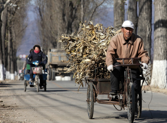 A farmer cycles on a road in Pinggu, Beijing.   Bloomberg