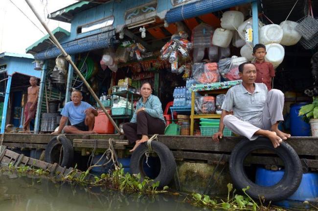 Cambodians sit in front of their shops at a floating village in Kampong Chhnang province, some 90 kilometers northeast of Phnom Penh.   AFP