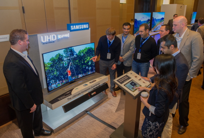 Samsung Electronics’ North American dealers observe the tech giant’s curved ultrahigh-definition televisions for the U.S. and Canadian markets during a conference in Dallas, Texas, last week.   Samsung Electronics