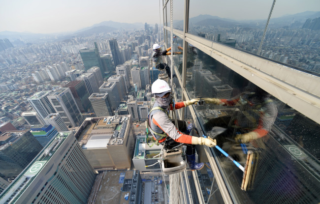 3일 오전 서울 강남구 삼성동 무역센터 봄맞이 외병청소가 실시돼 청소용역 직원들이 외줄에 의지해 청소를 하고 있다.<br />김명섭 기자 msiron@heraldcorp.com
Cleaners tied to safety equipment work on the 227-meter-tall Korea World Trade Center in Gangnam, Seoul, Monday.   Kim Myung-sub/The Korea Herald