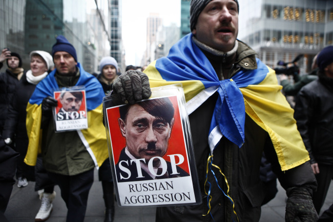 A man holds a sign during a protest against Russian military intervention in the Crimea region of Ukraine in New York on Sunday.   AFP-Yonhap
