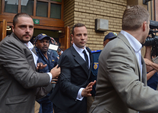 Oscar Pistorius (center) is escorted out of the high court after the first day of his trial in Pretoria, South Africa, Monday.   AP-Yonhap