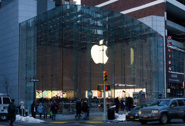 Pedestrians pass in front of an Apple Inc. store in New York.   Bloomberg
