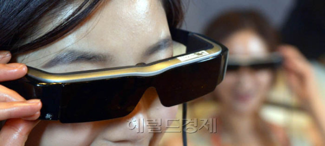 한국앱손은 5일 사용자들의 게임, 영상 및 일상생활 전반을 획기적으로 변화시킬 새로운 기능으로 무장한 2세대 스마트 안경 ‘모베리오 BT-200’을 선보였다. 모베리오 BT-200의 헤드셋 무게는 88g으로 1세대 제품보다 60% 가벼워졌으며 안경부에는 카메라와 블루투스가 새롭게 탑재되어 사용자들의 편의성을 한 단계 높였다.