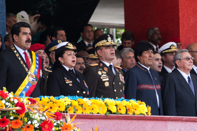 Venezuelan President Nicolas Maduro (left) sings the Venezuela’s national anthem accompanied by Bolivia’s President Evo Morales (second from right) and Cuba’s President Raul Castro (right) during the parade in honor of late Venezuelan President Hugo Chavez to mark the first anniversary of his death at Paseo Los Proceres in Caracas on Wednesday.   Xinhua-Yonhap
