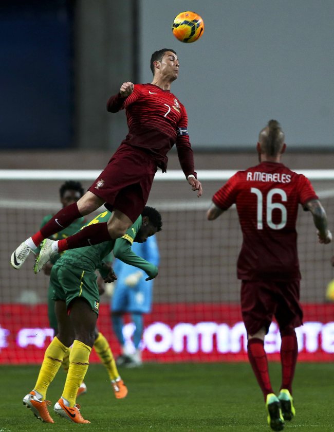 Portugal’s Cristiano Ronaldo (center) in action against Alexander Song (left) of Cameroon during the international friendly football match between Portugal and Cameroon at Magalhaes Pessoa Stadium in Leiria, Portugal, Wednesday.   EPA-Yonhap