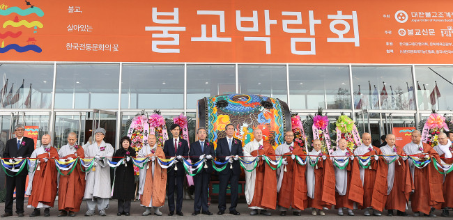 Culture Minister Yoo Jin-ryong (eighth from left), Rep. Chung Mong-joon (ninth from left) and Ven. Jaseung (10th from left), chief of the Jogye Order of Korean Buddhism, cut the ribbon to open the Buddhism Expo 2014 at Seoul Trade Exhibition and Convention Center in southern Seoul on Thursday.   Yonhap