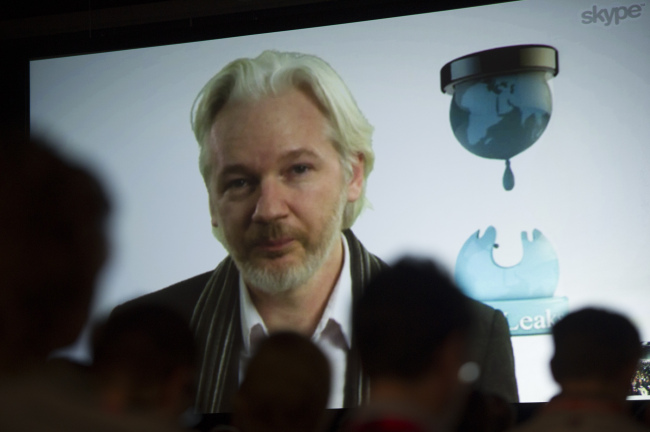 Julian Assange, founder of WikiLeaks, speaks on screen during a panel discussion at the South By Southwest Interactive Festival in Austin, Texas, Saturday.   Bloomberg