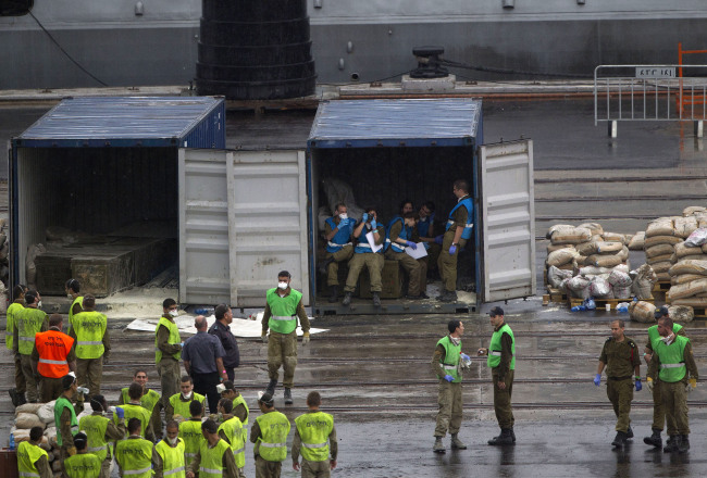 Israeli soldiers work around containers containing missiles and weapons unloaded from the seized Klos-C civilian cargo ship in the military port at the Red Sea city of Eilat, Israel, Sunday.   AP-Yonhap