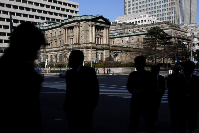 Pedestrians pass in front of the Bank of Japan headquarters in Tokyo.   Bloomberg