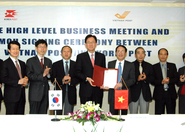 4단 컬러
Korea Post president Kim Joon-ho (fourth from left) and Pham Anh Tuan (third from right), president and CEO of Vietnam Post, pose with executives after signing a memorandum of understanding to strengthen ties between the two postal services in Hanoi, Vietnam, Tuesday.   Korea Post