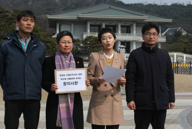 Opposition party officials protest over the spy agency’s alleged evidence fabrication in front of Cheong Wa Dae on Tuesday.  Yonhap
