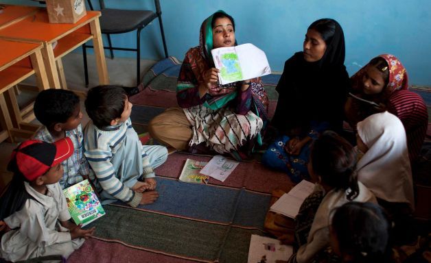 Educator Humaira Bachal shows an illustration to students in Karachi, Pakistan.   AP