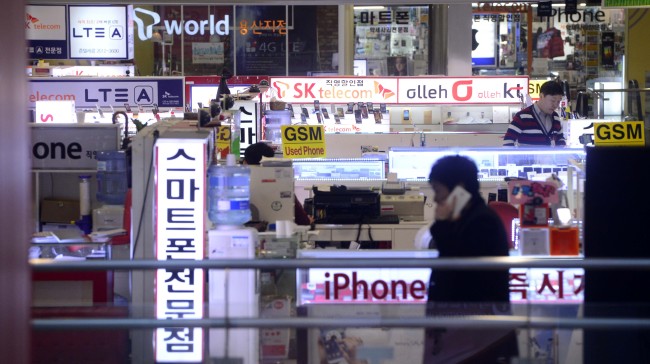 A customer walks past business counters of telecom companies in Yongsan, Seoul, Thursday.   Park Hae-mook/The Korea Herald