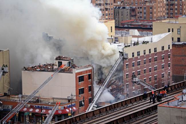 Firefighters respond to a fire and building collapse in the Harlem neighborhood of Manhattan, New York, Wednesday.   AFP-Yonhap