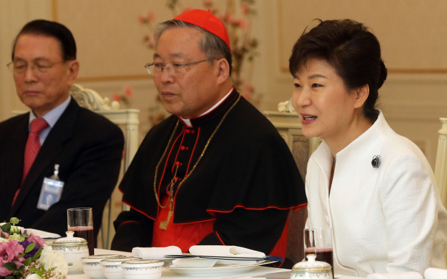 President Park Geun-hye (right) attends a luncheon at Cheong Wa Dae on Friday to congratulate Korea’s newly appointed Cardinal Andrew Yeom Soo-jung (center) and to honor the Catholic community’s role in facilitating the pope’s planned visit to Seoul in August.   Park Hyun-koo/The Korea Herald