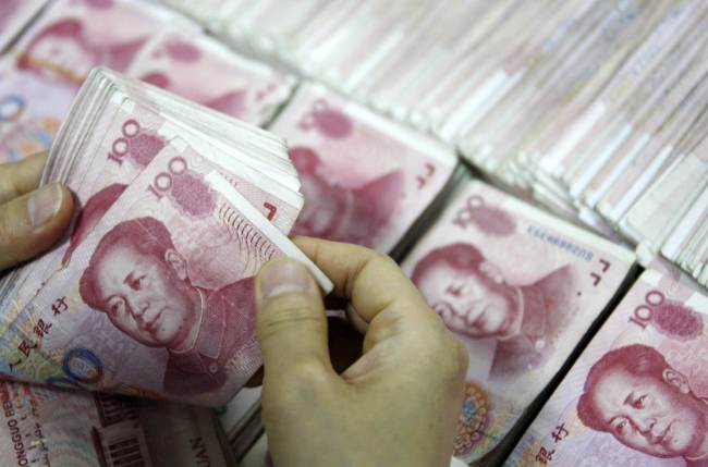 100 yuan bank notes being counted at a bank in Huaibei, in eastern China’s Anhui province.    AFP-Yonhap