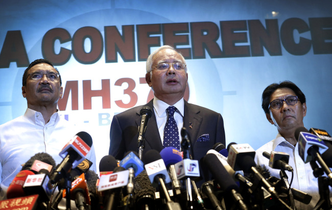 Malaysian Prime Minister Najib Razak (center), accompanied by Minister for Transport Hishamuddin Hussein (left) and Director General of the Malaysian Department of Civil Aviation Azharuddin Abdul Rahman, delivers a statement to the media regarding missing Malaysia Airlines jetliner MH370 in Sepang, Malaysia, Saturday.   AP-Yonhap