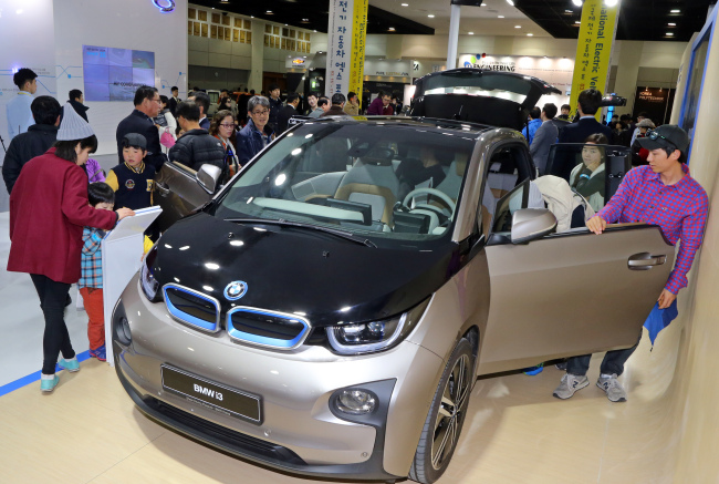 Visitors check out a BMW i3 compact at the International Electric Vehicle Expo held on Jejudo Island on Saturday.    Yonhap