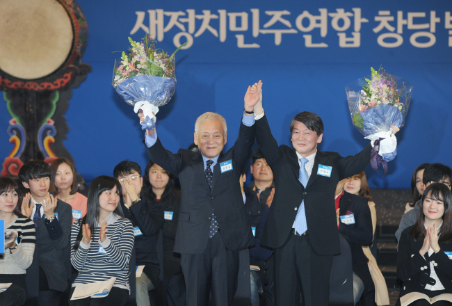 Democratic Party leader Kim Han-gil (left) and independent Rep. Ahn Cheol-soo express gratitude after being elected co-leaders of a committee to launch their new coalition party at the Sejong Center for Performing Arts in Seoul on Sunday.   Ahn Hoon/The Korea Herald