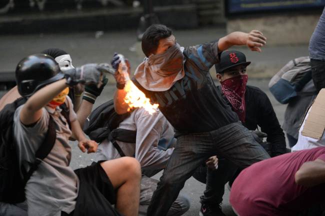 Demonstrators clash with members of the national guard during a protest against Venezuelan President Nicolas Maduro in Caracas on Saturday.   AFP-Yonhap