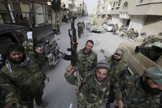 Pro-government forces stand in a street in the Syrian town of Yabroud on Sunday after they seized full control of the rebel bastion in the strategic Qalamun region near the Lebanese border.   AFP-Yonhap