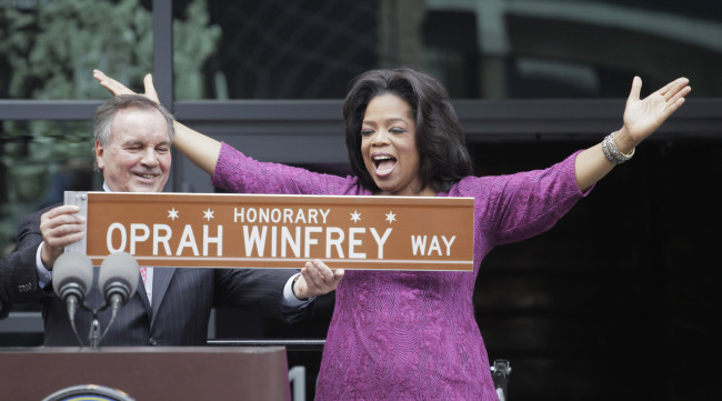 This May 11, 2011, file photo shows Chicago Mayor Richard M. Daley presenting TV talk-show host Oprah Winfrey with a sign after a street was named in her honor outside her Harpo Studios in Chicago.    AP-Yonhap