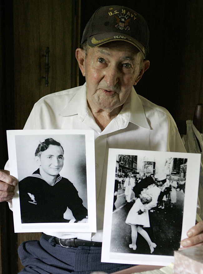 Glenn McDuffie holds a portrait of himself as a young man (left) and a copy of Alfred Eisenstaedt’s iconic Life magazine shot of a sailor, who McDuffie claimed was him, embracing a nurse in a white uniform in New York’s Times Square, at his Houston home.   AP-Yonhap