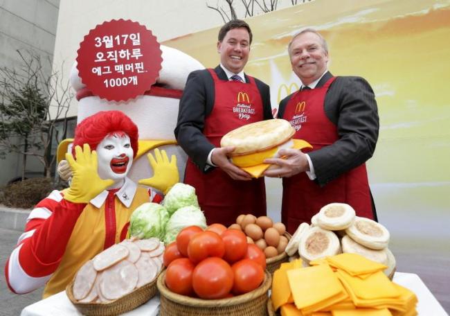 Joe Erlinger (left), managing director of McDonald’s Korea, and Bob Larson, greater Asia senior vice president of McDonald’s, pose with a giant Egg McMuffin during the National Breakfast Day event on Monday at the Gwanhun-dong branch.   McDonald’s Korea