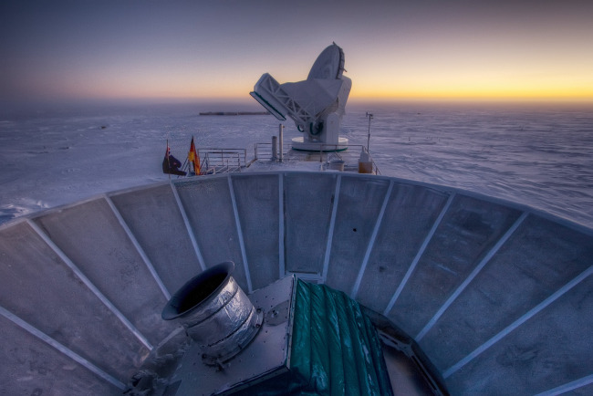 The sun sets behind the BICEP2 Telescope (foreground) and the South Pole Telescope in Antarctica.   AP-Yonhap News