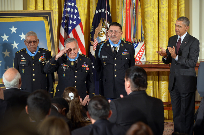 President Barack Obama applauds after awarding the Medal of Honor to Staff Sgt. Melvin Morris (left), Sgt. 1st Class Jose Rodela (center) and Specialist Four Santiago Erevia for actions during the Vietnam War, during a ceremony in the East Room of the White House in Washington on Tuesday.   UPI-Yonhap