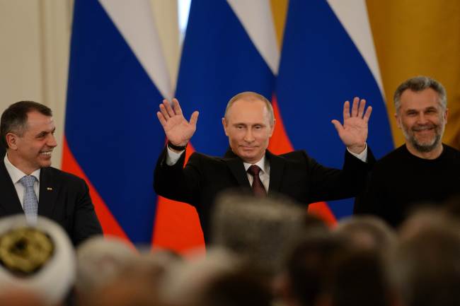 Russia’s President Vladimir Putin (center) gestures after signing a treaty on Ukraine’s Crimean Peninsula becoming part of Russia in the Kremlin in Moscow on Tuesday, with Crimean Parliament Speaker Vladimir Konstantinov (left) and Alexei Chaly, Sevastopol’s new de facto mayor. AFP-Yonhap