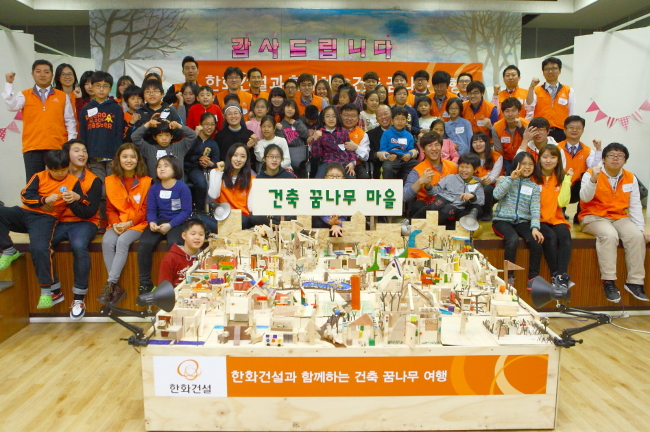 한화건설 김영수 전무(사진 앞에서 두번째줄 중앙)와 한양대 건축학부장 서현 교수(“오른쪽), 서울특별시 꿈나무마을 강효봉 원장(“ 왼쪽)이 ‘건축 꿈나무 육성 사회공헌활동’ 업무협약을 체결하고 꿈나무 마을 어린이들을 비롯한 한화건설-한양대 연합봉사단과 기념촬영을 하고 있다.