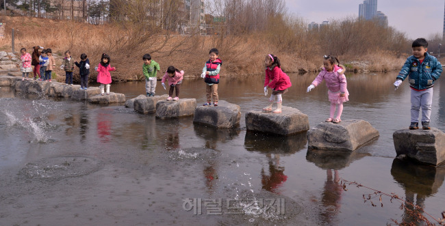 22일 세계 물의 날 을 맞아 서초구는 20일 서울 서초구 양재천에서 희망우물 설치를 위한 모금행사와 하천정화활동을 펼쳤다. 행사에 참가한 어린이들이 수질 개선과 악취 제거에 효과가 있는 EM(Effective Micro-organisims) 흙공 던지기를 하고 있다.
