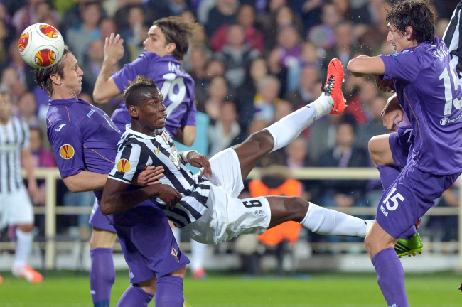 Juventus midfielder Paul Pogba (center) jostles with Fiorentina midfielder Massimo Ambrosini (left) during an Europa League, round of 16, return-leg soccer match between Fiorentina and Juventus at the Artemio Franchi stadium in Florence, Italy, Thursday.   AP-Yonhap