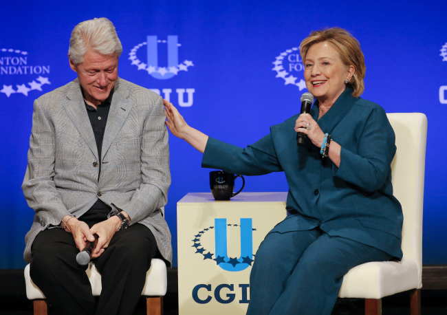 Former President Bill Clinton (left) listens as former Secretary of State Hillary Rodham Clinton speaks during a student conference for the Clinton Global Initiative University at Arizona State University in Tempe, Arizona, Saturday.   AP-Yonhap