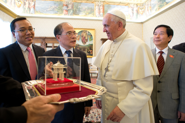 In this picture made available by the Vatican newspaper L’Osservatore Romano, Pope Francis exchanges gifts with Nguyen Sinh Hung (second from right), chairman of the national assembly of Vietnam, at the Vatican, Saturday.   AP-Yonhap