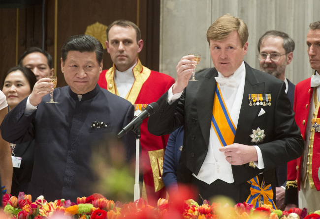 China’s President Xi Jinping (left) and Dutch King Willem Alexander propose a toast during the official state banquet at the royal palace in Amsterdam on Saturday.   AP-Yonhap
