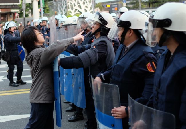 A protester scuffles with police outside the Executive Yuan during a demonstration in Taipei early Monday, following Taiwanese President Ma Ying-jeou’s refusal to scrap a contentious trade agreement with China. Dozens of people were detained in Taipei after violent clashes erupted between police and protesters.   AFP-Yonhap