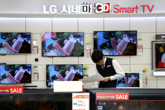 An employee works in front of LG Electronics’ Cinema 3-D televisions in Seoul. Bloomberg