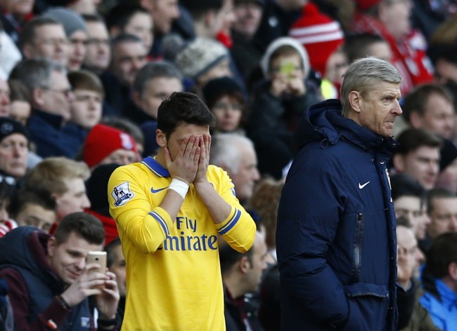 Arsenal's Mesut Ozil (left) prepares to come on as a substitute as manager Arsene Wenger (right) reacts during their English Premier League soccer match against Stoke City at the Britannia stadium in Stoke-on-Trent, central England March 1, 2014. (AP-Yonhap)