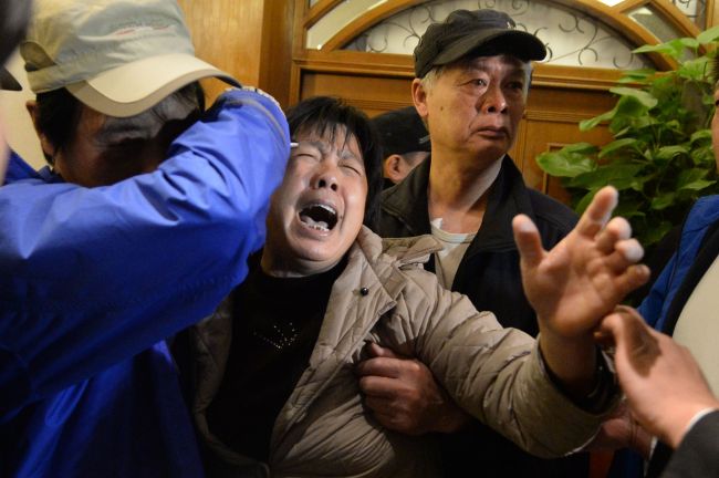 A relative (C) of passengers on Malaysia Airlines flight MH370 cries after hearing the news that the plane plunged into Indian Ocean at a hotel in Beijing on March 24, 2014. (AFP)