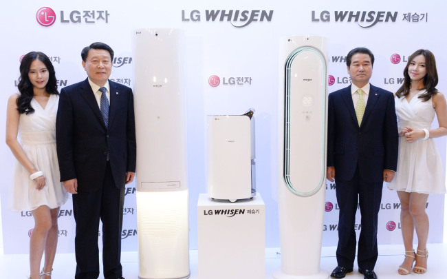 Nho Hwan-yong (second from left), president of LG Electronics’ Air Conditioning & Energy Solution Company, poses with the new Whisen air conditioner and dehumidifier at a press event in Seoul on Tuesday. LG Electronics