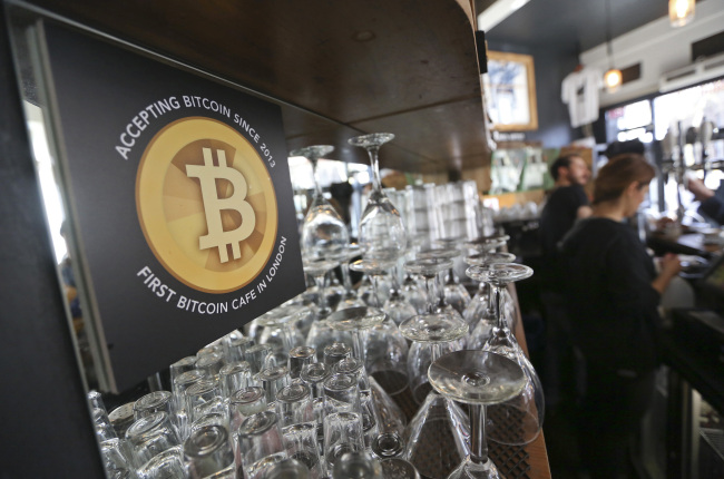 A poster alerting customers that the digital currency Bitcoin is accepted as payment sits behind the counter inside the Old Shoreditch Station cafe in London.   Bloomberg