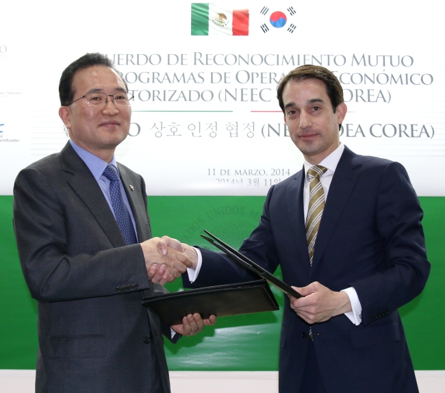 Korea Customs Service Commissioner Baek Un-chan (left) shakes hands with Alejandro Chacon Dominguez, Mexico’s general customs administrator, after the two sides agreed to sign a customs agreement in March 2014.   KCS