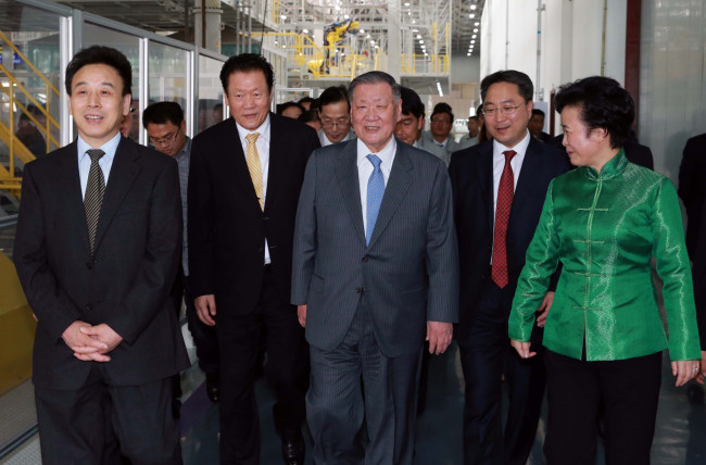 Hyundai Motor Group chairman Chung Mong-koo (center) and other company and city officials walk along the production line of the Hyundai Trago luxury cargo truck at the Sichuan Hyundai plant in western China on Wednesday.   Hyundai Motor