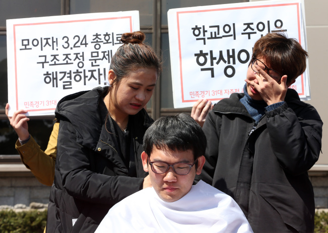 Members of the student council of Kyonggi University’s Seoul campus prepare to shave their heads in protest of the school’s organizational overhaul on Friday.   Yonhap