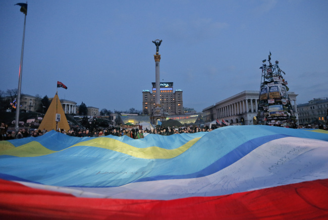 People hold a large Ukrainian-Crimean-Crimean Tatar flag during a rally in Kiev on Thursday.   AP-Yonhap